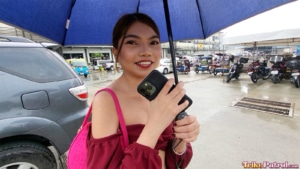 Pretty Pinay model stands under umbrella in Manila to stay dry