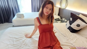Cute Pinay babe sits on edge of hotel bed