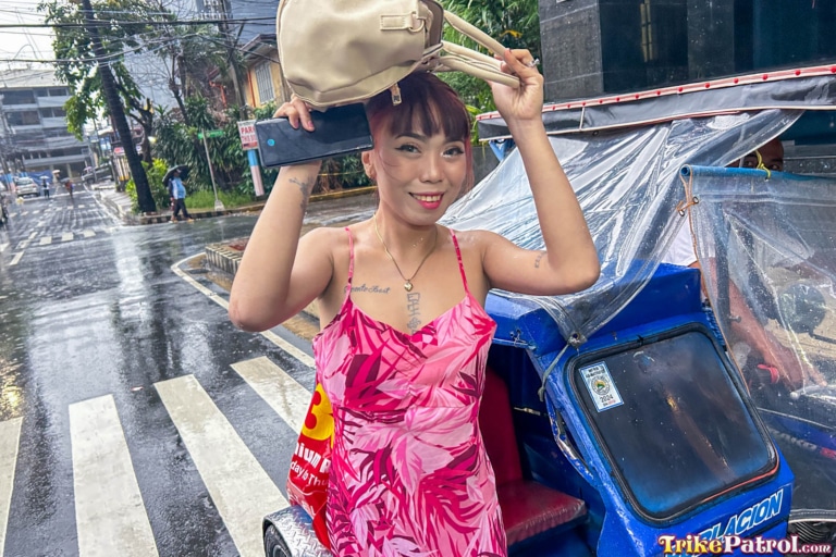Beautiful Filipina shields herself from the rain in downtown Manila